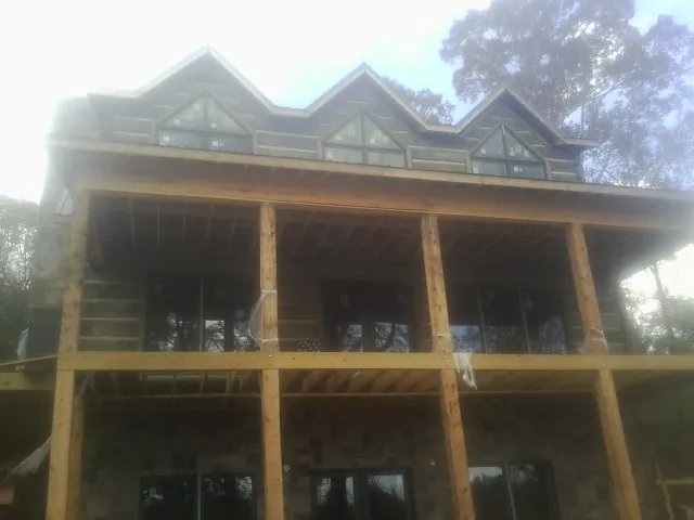 Dormers and porch framing on a large log home under construction — Roof Coating work by our crew in Feasterville Trevose
