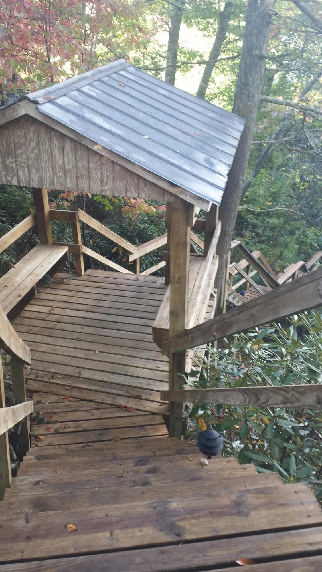 Metal roofed shelter over wooden steps on a wooded walkway — Skylight Repair & Installation work by our crew in Feasterville Trevose